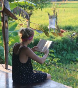 Woman reads book in Guatemala at a 200 hour yoga teacher training retreat