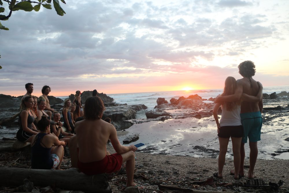 Students receiving yoga teacher training on the beach in Costa Rica