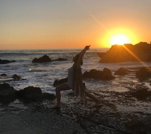 Sun Salutation (Surya Namaskar) yoga pose on the beach